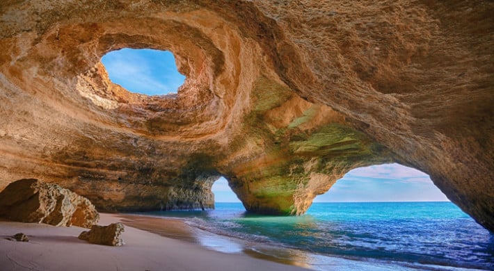 Gruta litoral Algarve, praia e águas azuis.