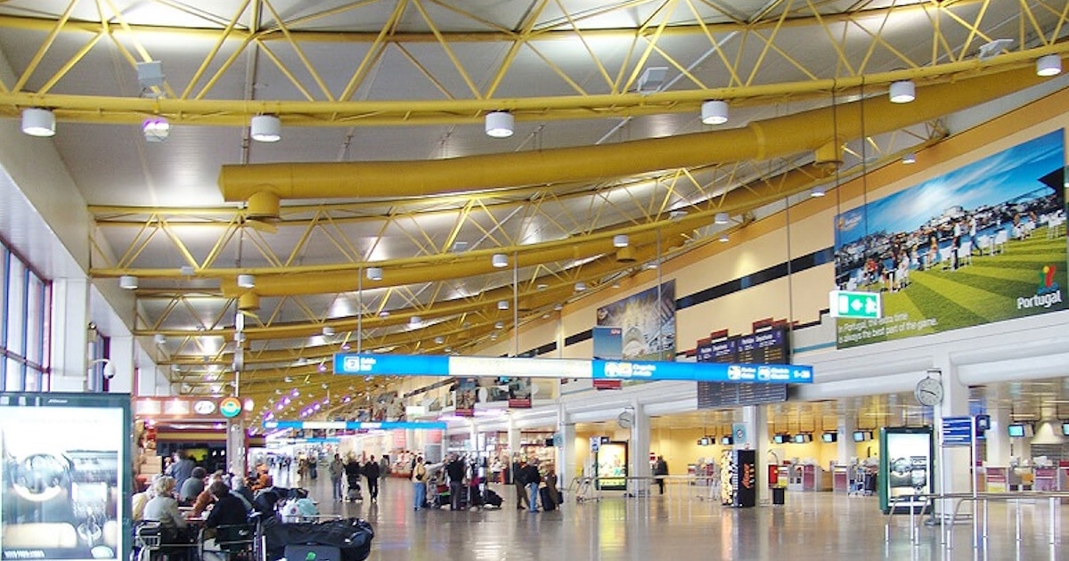 Terminal de aeroporto movimentado com passageiros.