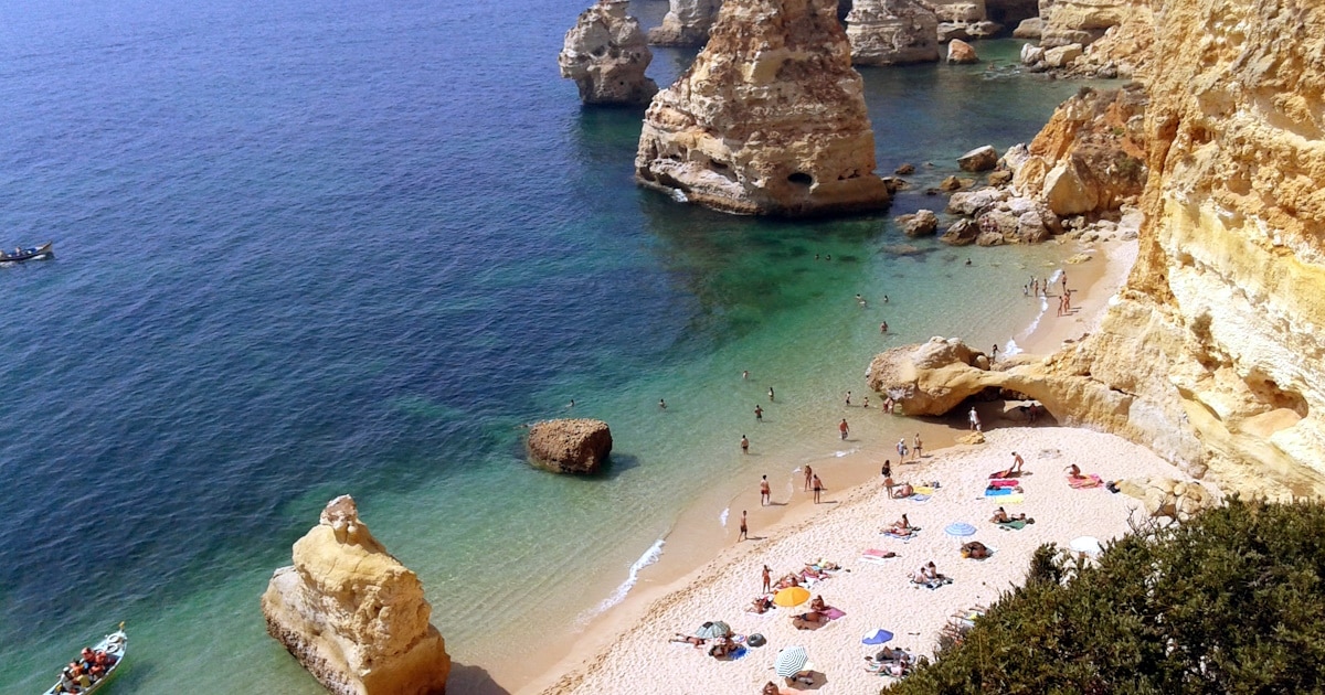 Praia com falésias e mar azul em Portugal.